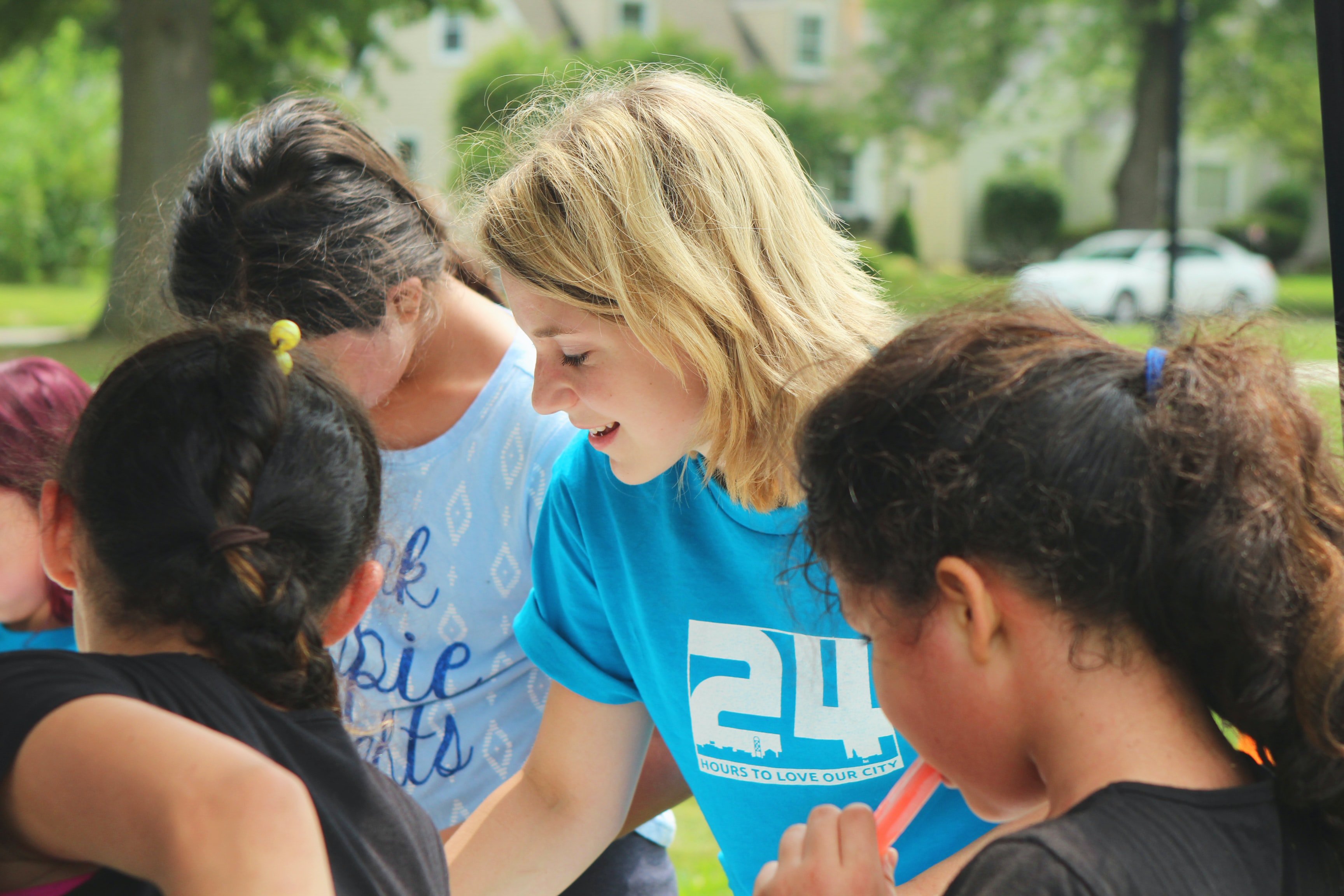 Blonde woman in blue shirt volunteering around children