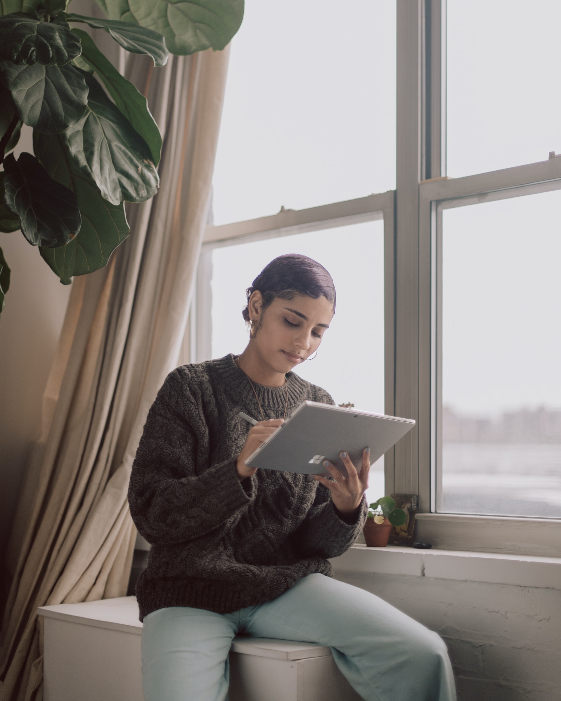 Woman looking at tablet, writing something. 